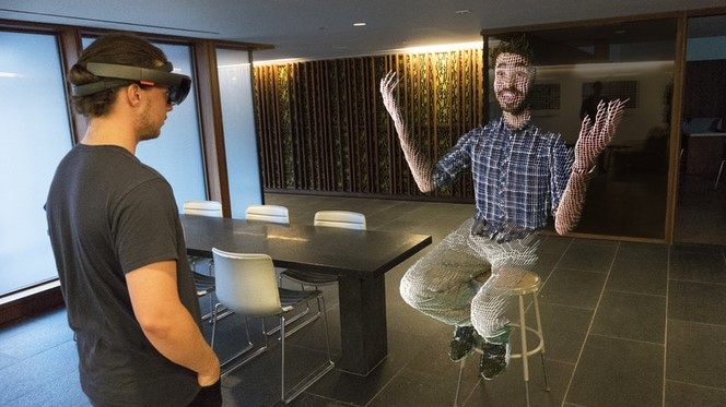 Teleporting technology is shown in the picture where a person is meeting another person via hologram technology